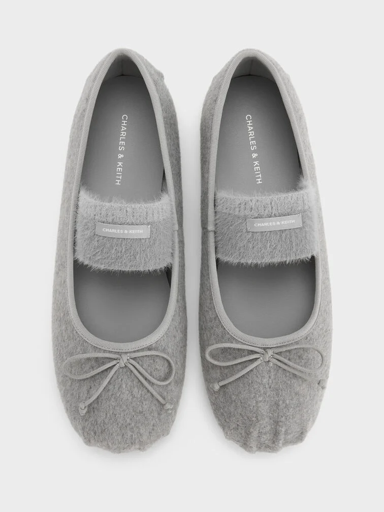 Light-grey felt Mary Jane flats require fabric-safe water-repellent sprays for effective waterproofing.