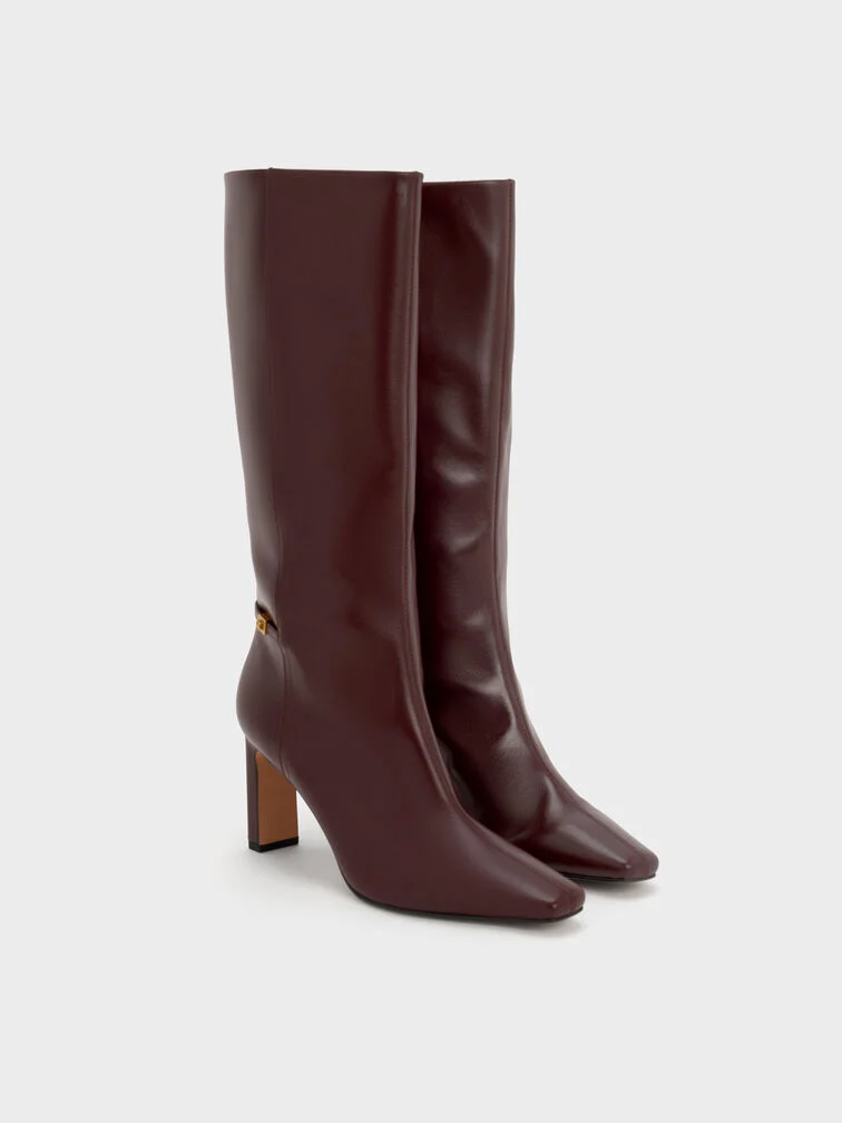 Botas de cano alto bordeaux adicionam um ponto de cor rico a qualquer look winter white.