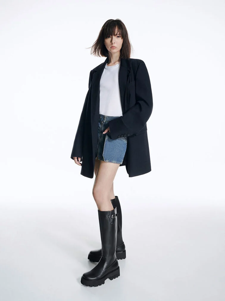 Black chunky-soled knee-high boots paired with a white T-shirt, a denim skirt and a black blazer.