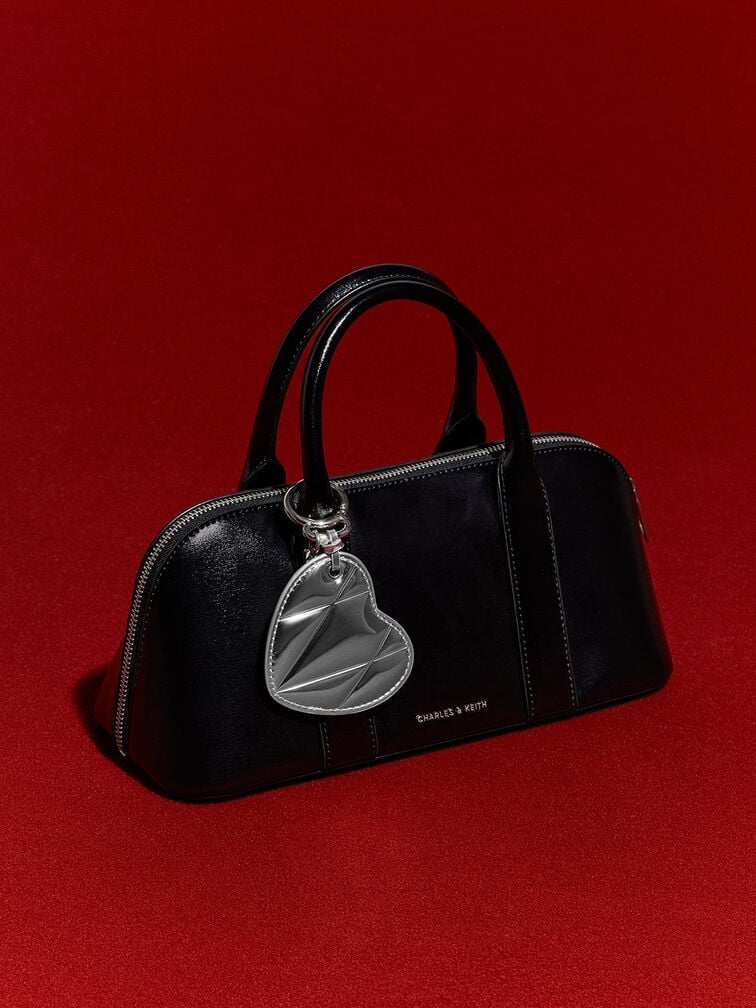 This quilted silver heart charm can add a playful touch to a black top-handle bag.