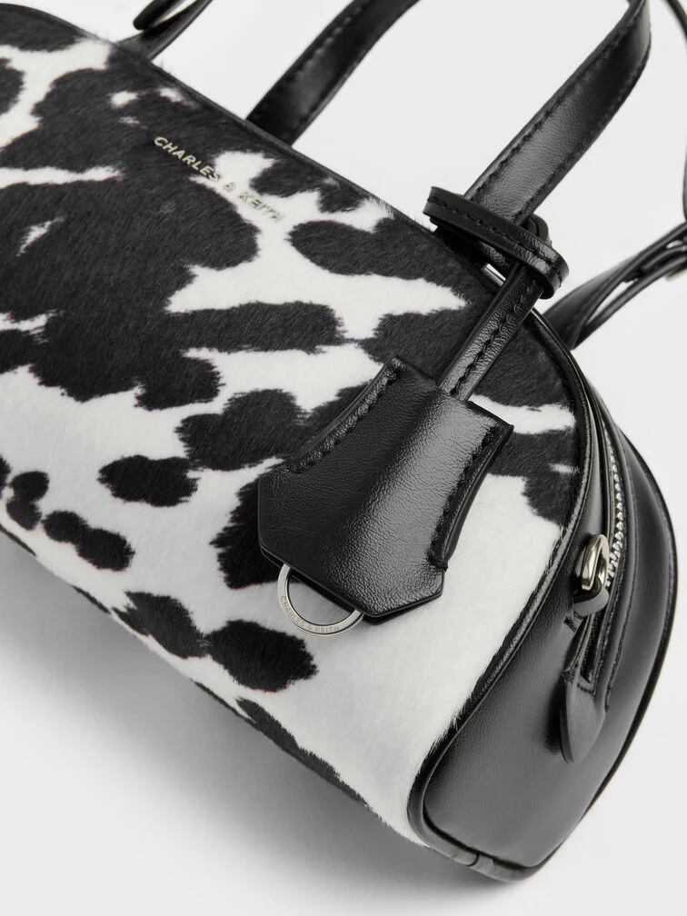 Bold and eye-catching, a cow-print bag works well as a statement piece. 
