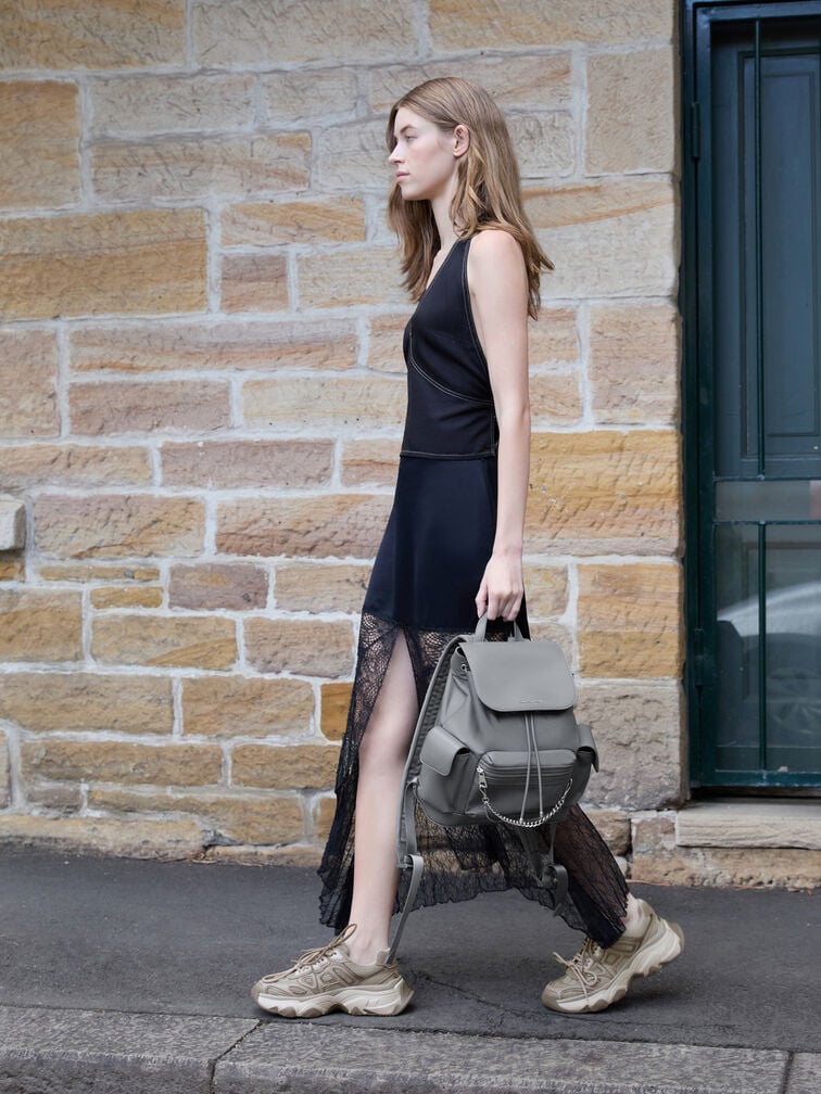 Chunky low-top sneakers pairs effortlessly with a flowy black maxi dress