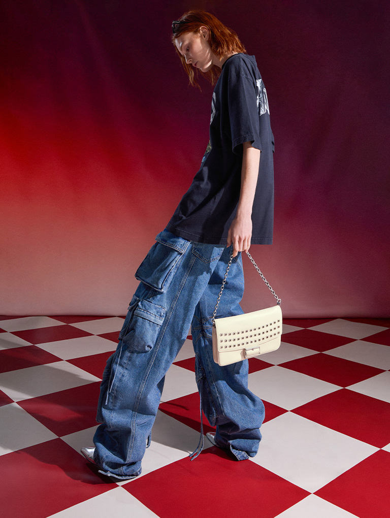 The Liv grommet chain-handle shoulder bag carried by a model   - CHARLES & KEITH