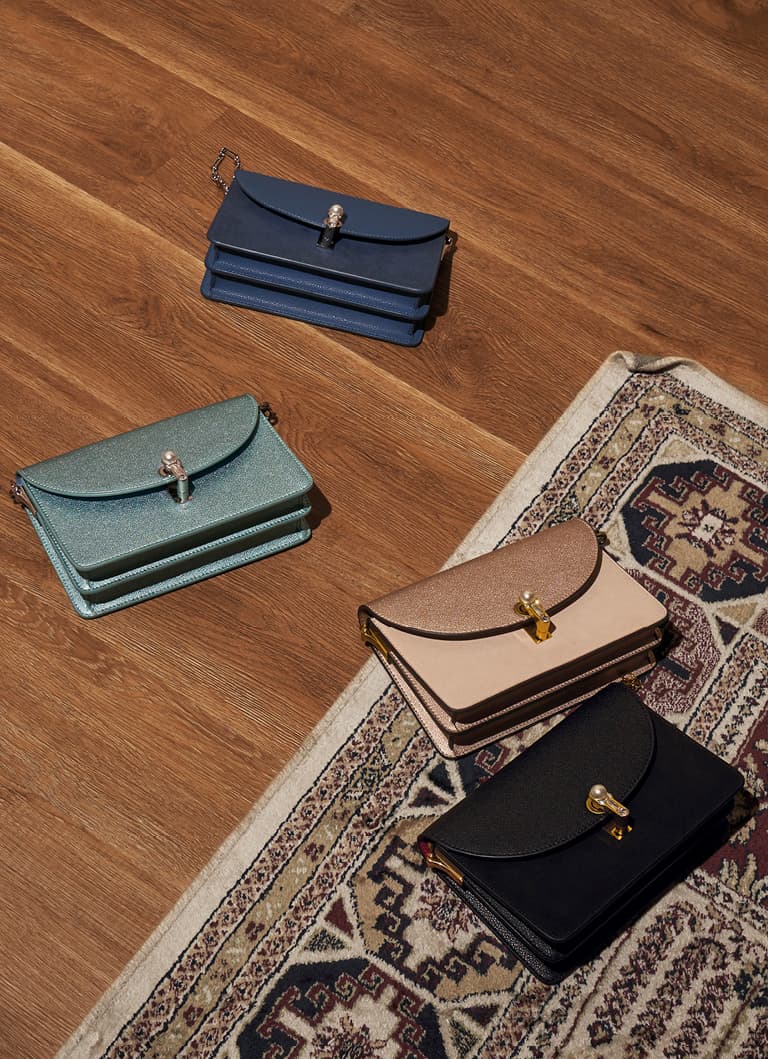 A flat lay of turn-lock clutches in black, blue, light blue and nude – CHARLES & KEITH