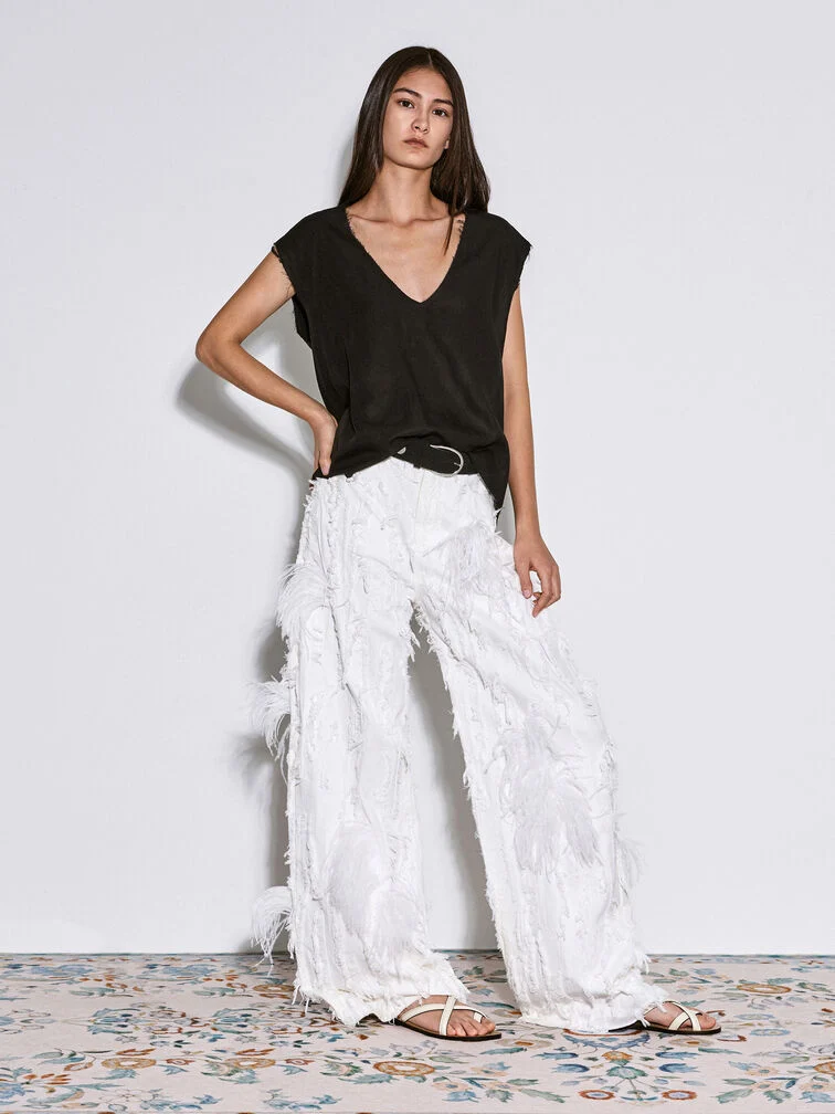 Pair detail-rich wide leg pants with simple footwear to create a bold yet refined aesthetic.