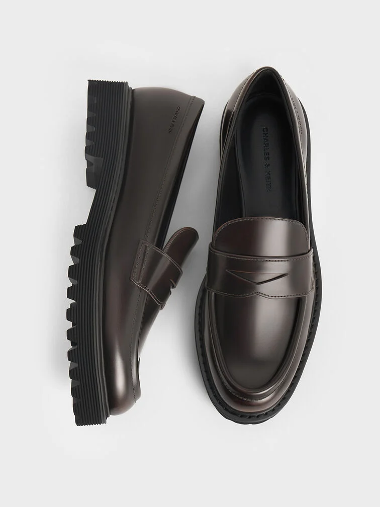Classic penny loafers feature distinctive cut-out straps across the vamps.