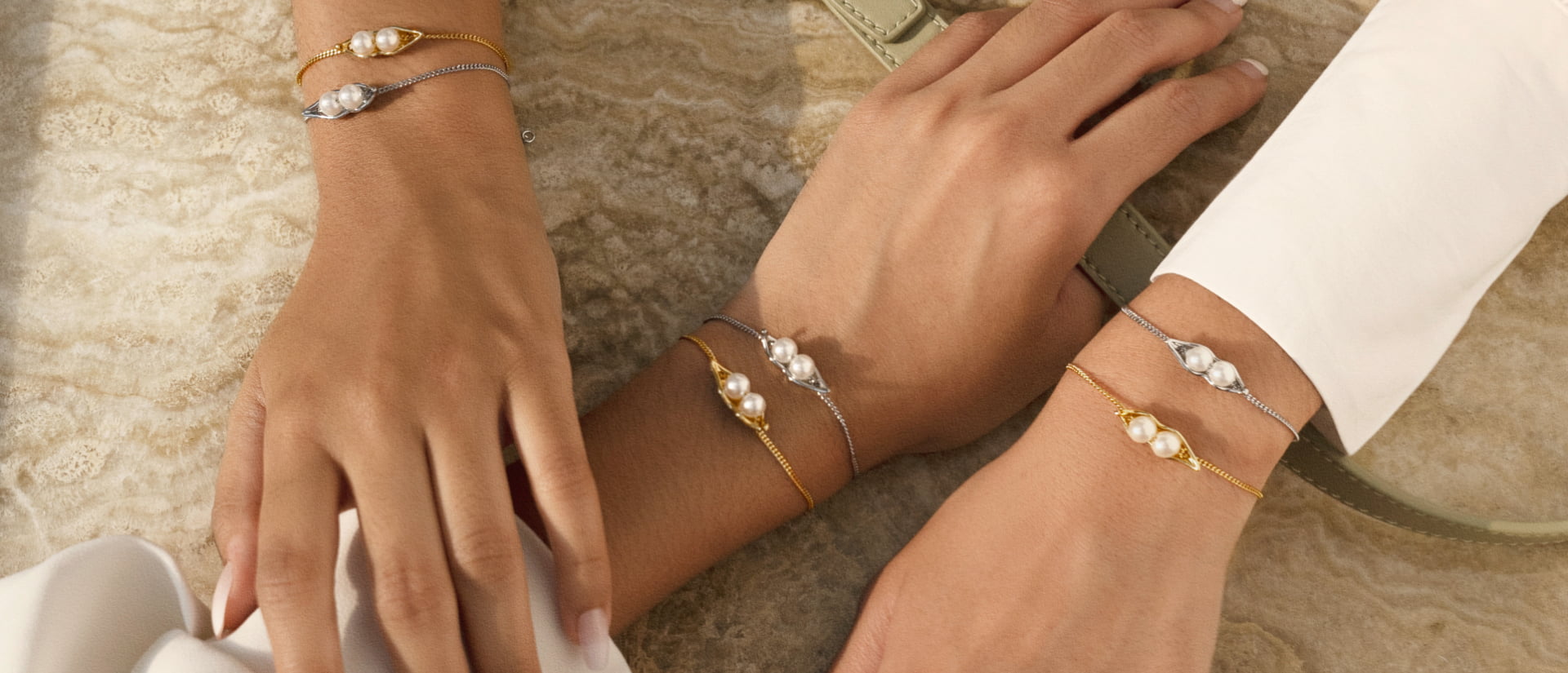 Women’s ‘Peas In A Pod’ friendship bracelet in gold and silver (hand close-up) - CHARLES & KEITH