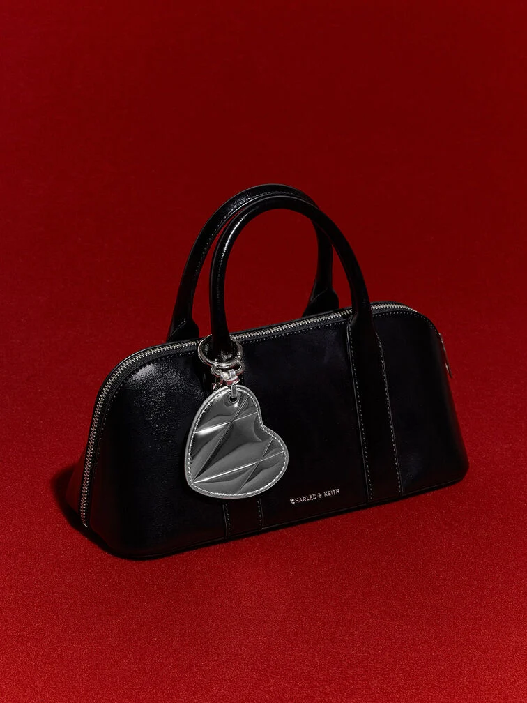  A metallic heart bag charm on a black bag for a cool-girl look