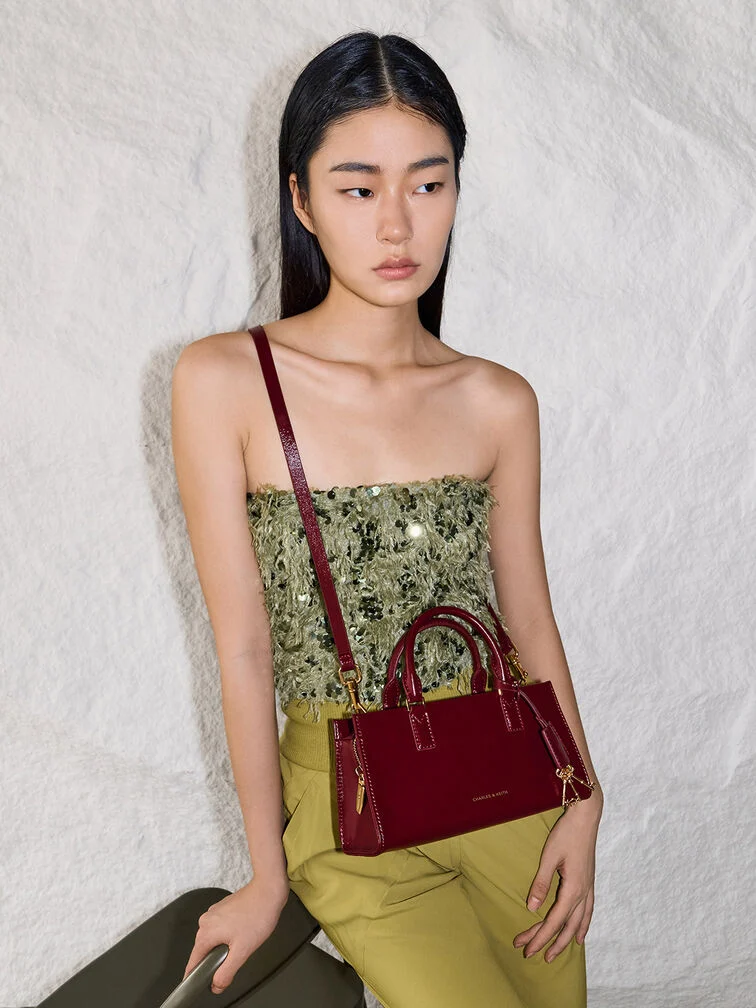 Small plum top-handle bag as a Secret Santa gift idea for women who like to travel light. 