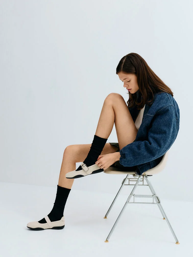 Chalk faux suede Mary Jane sneakers paired with black crew socks for a chic, layered look.