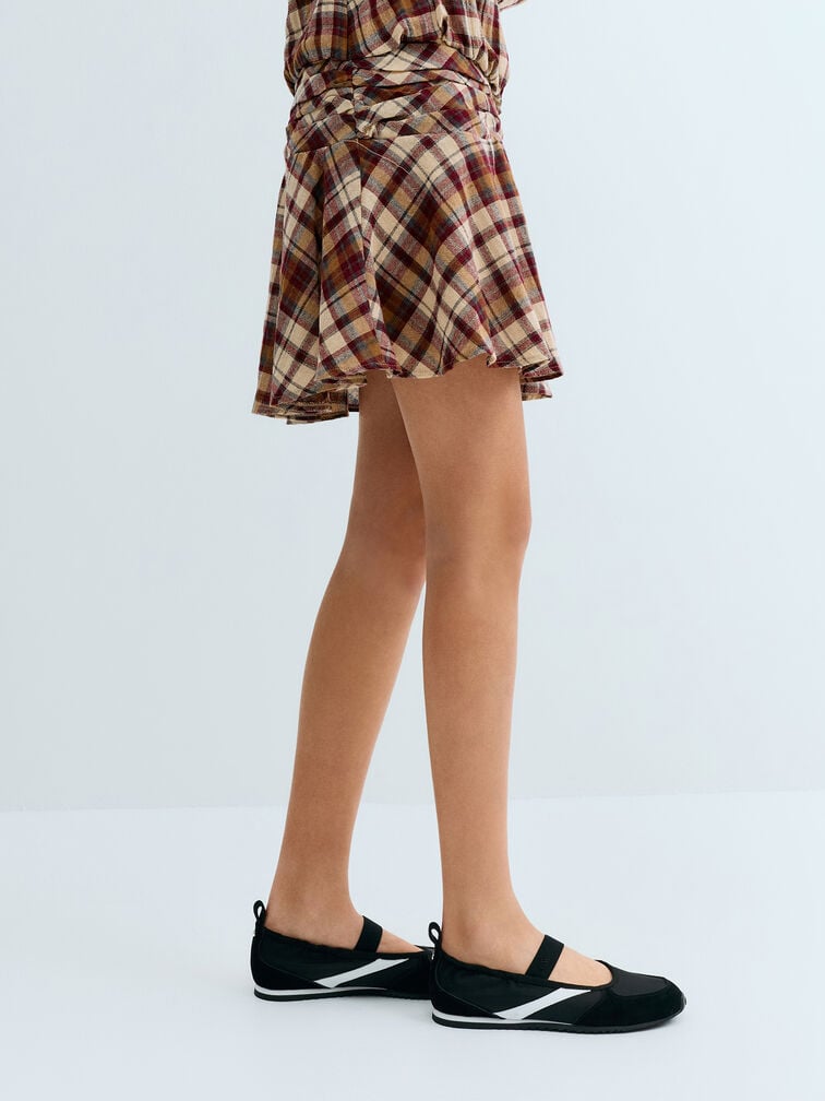 Black Mary Jane sneakers with white accents exude a sporty-chic aesthetic.