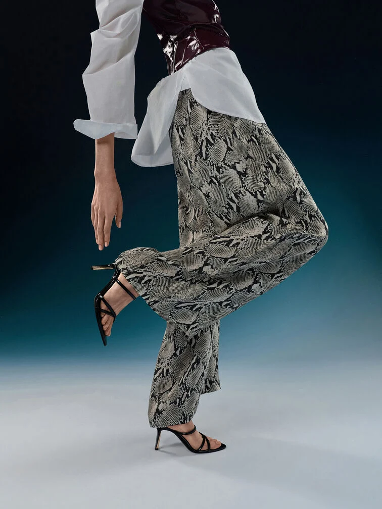 When styled with wide leg pants, strappy heeled sandals bring a feminine touch and a sense of lightness to the bottom-heavy outfit.