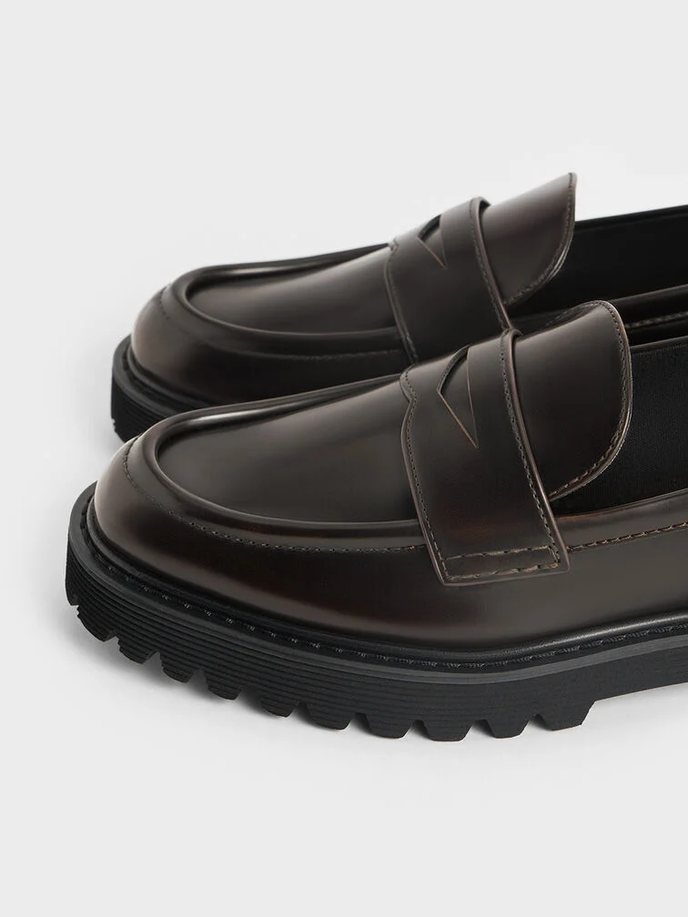 Classic penny loafers feature distinctive cut-out straps across the vamps.