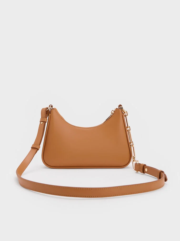 Un bolso crossbody marrón neutro te permite ir con las manos libres. 