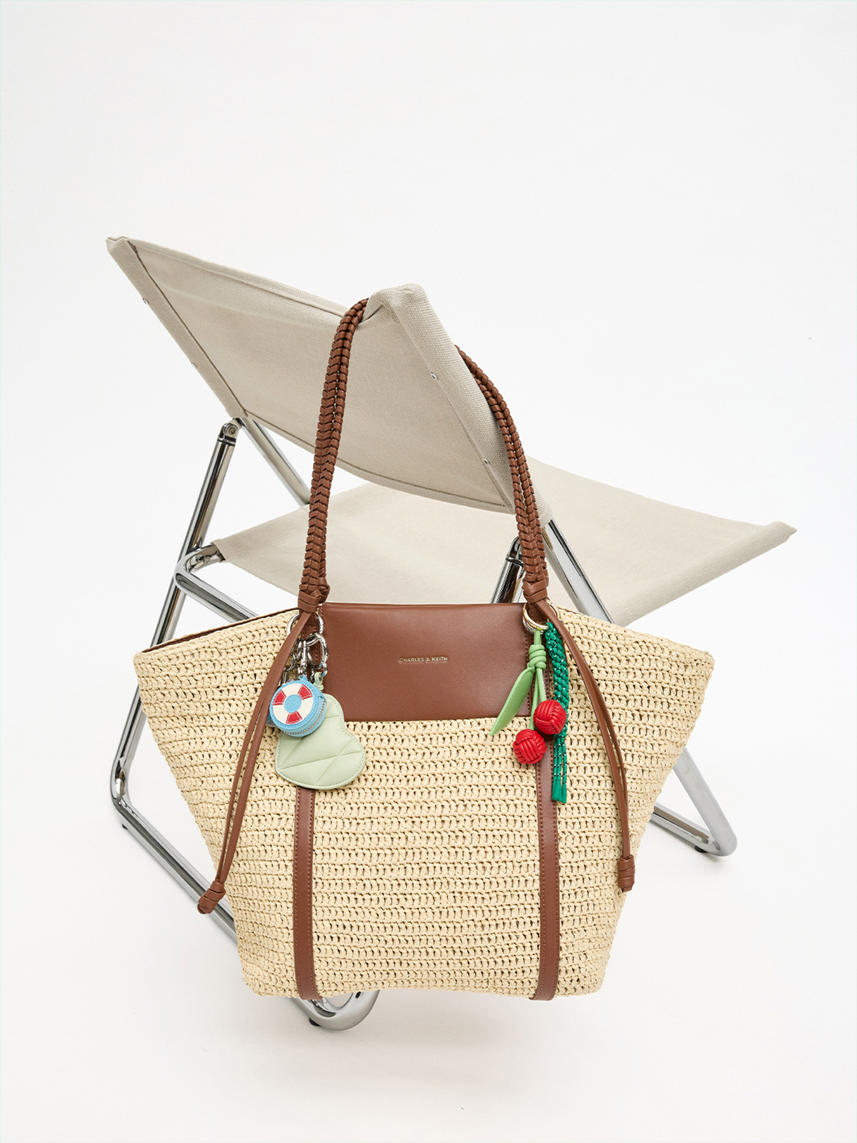 The Shalia straw tote bag with the swim ring, cherry, heart mirror bag charms - CHARLES & KEITH