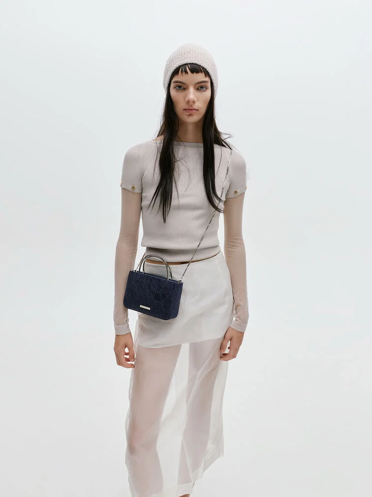 A mini bag offers just enough space for small essentials and comes with a chain strap for hands-free convenience.