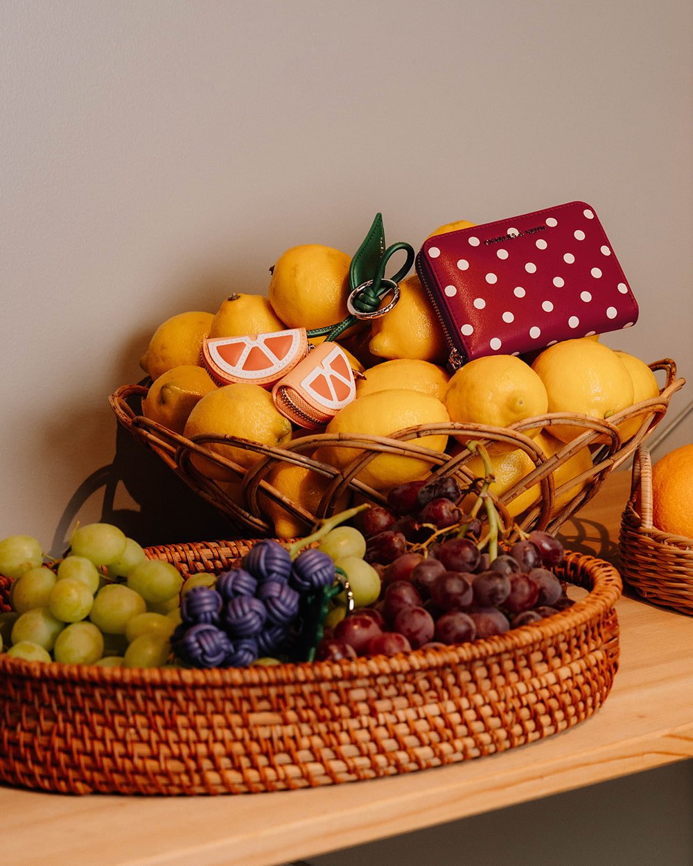 Sianna polka-dot wristlet in equestrian red, along with the orange charm - CHARLES & KEITH